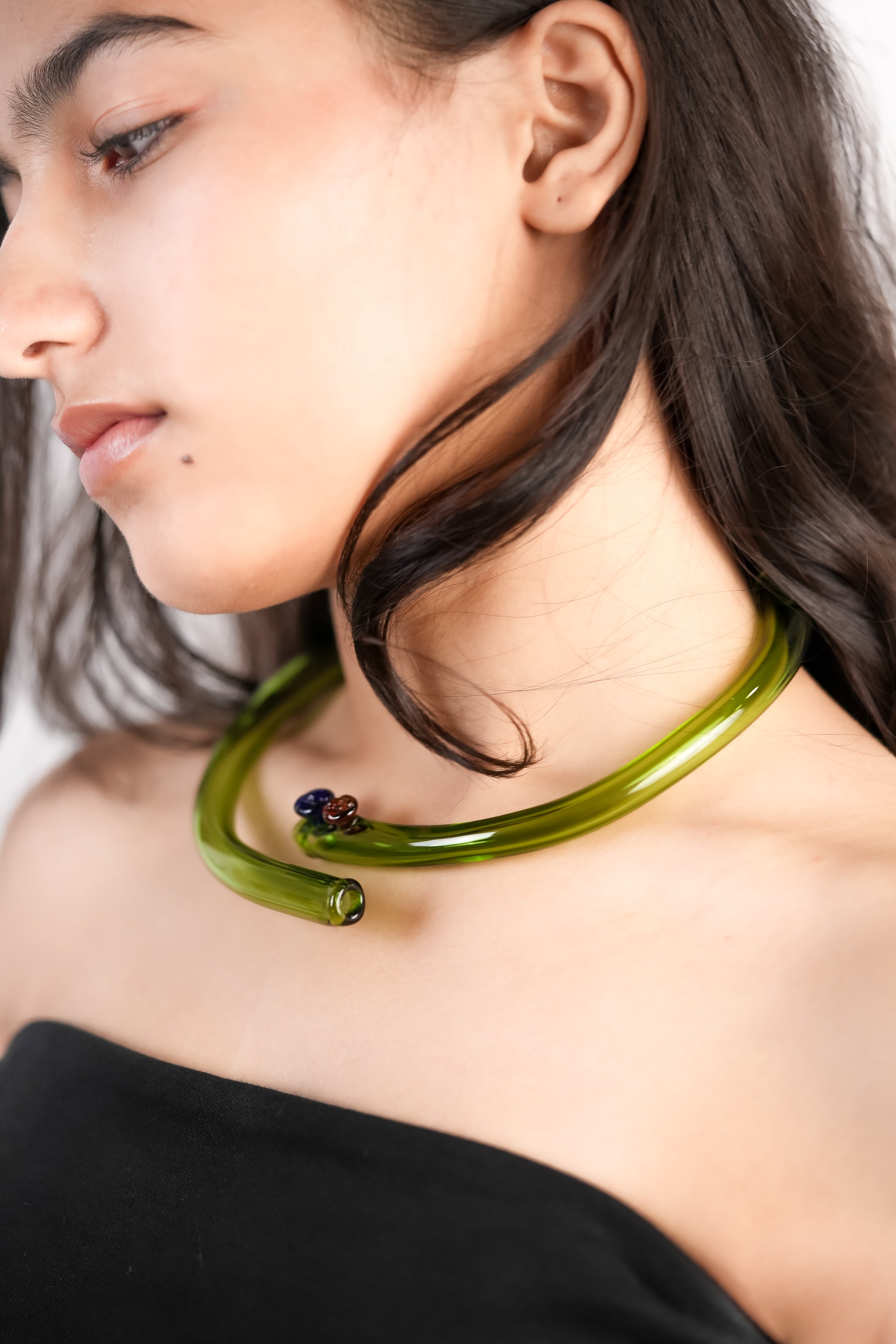 Model wearing handcrafted borosilicate glass choker in green by AIROKAD STUDIO.