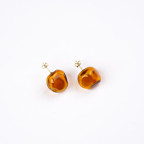 Handmade borosilicate glass studs in amorphous shape in amber by AIROKAD STUDIO.