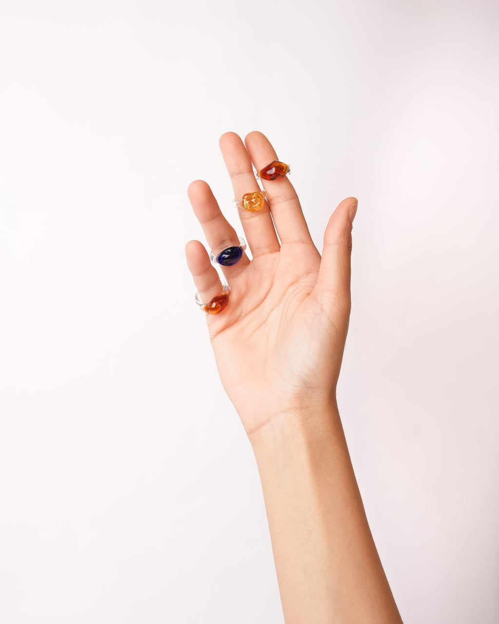 model wearing rocks of gibraltar in amber, yellow and blue handcrafted with borosilicate glass by AIROKAD STUDIO.