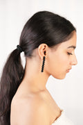 Model wearing handcrafted borosilicate black beaded drop earring with transparent bead detailing by AIROKAD STUDIO.