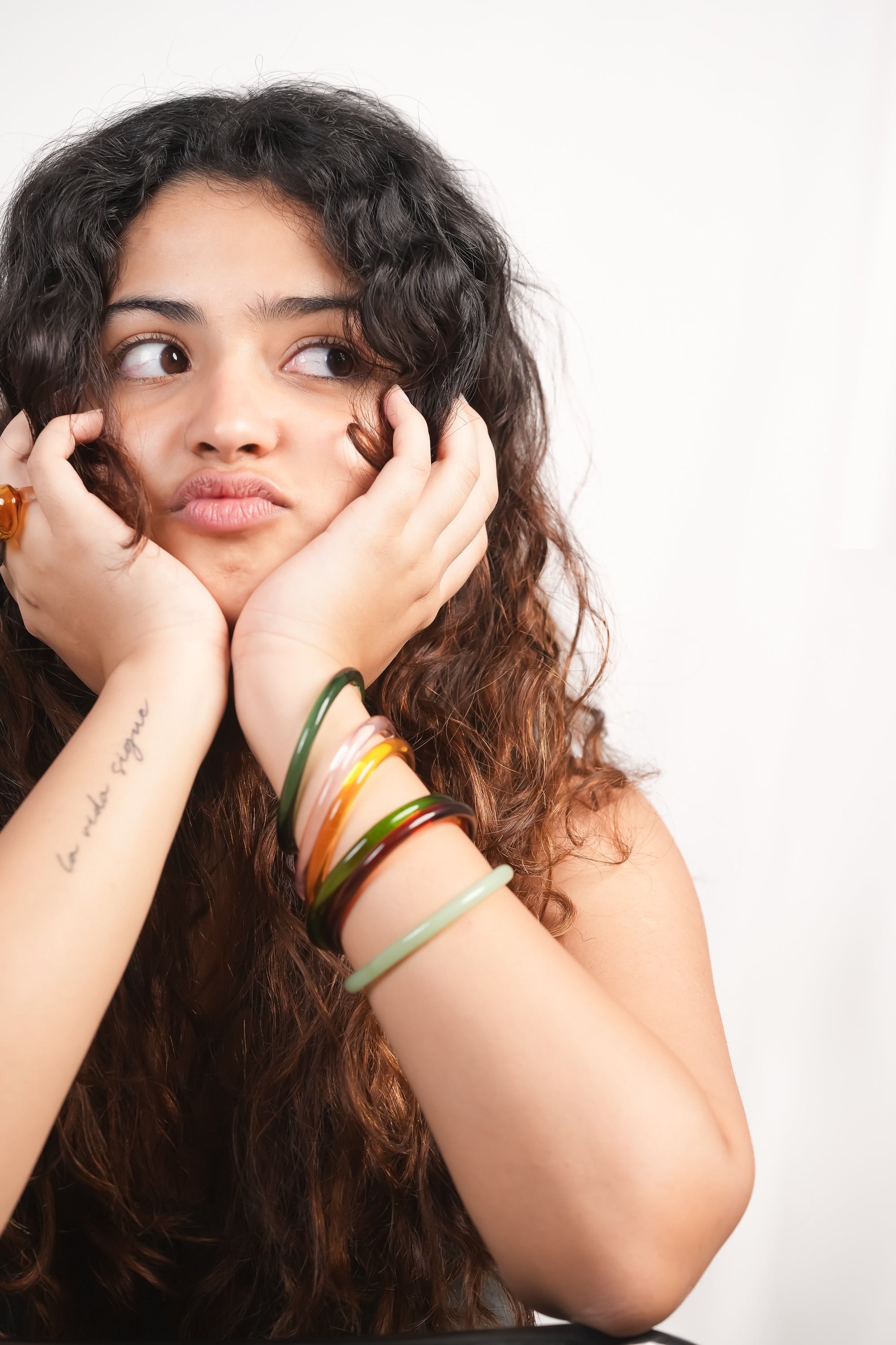 Model wearing handmade borosilicate glass bangles in various colors by AIROKAD STUDIO. 