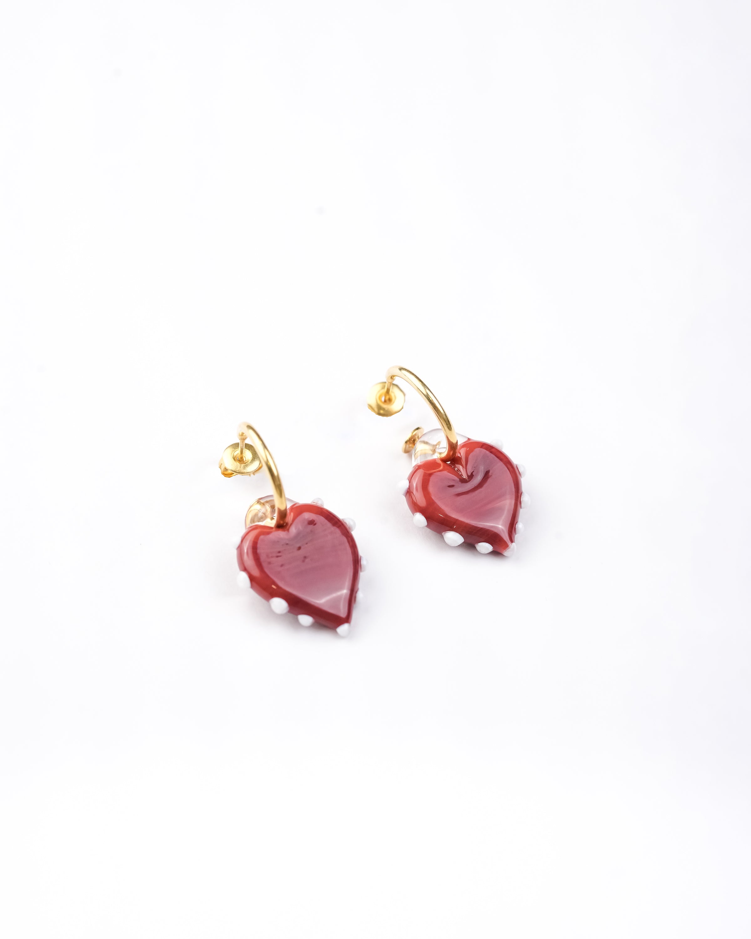 Handcrafted borosilicate glass red heart shaped hoop earrings with white dot detailing by AIROKAD STUDIO.