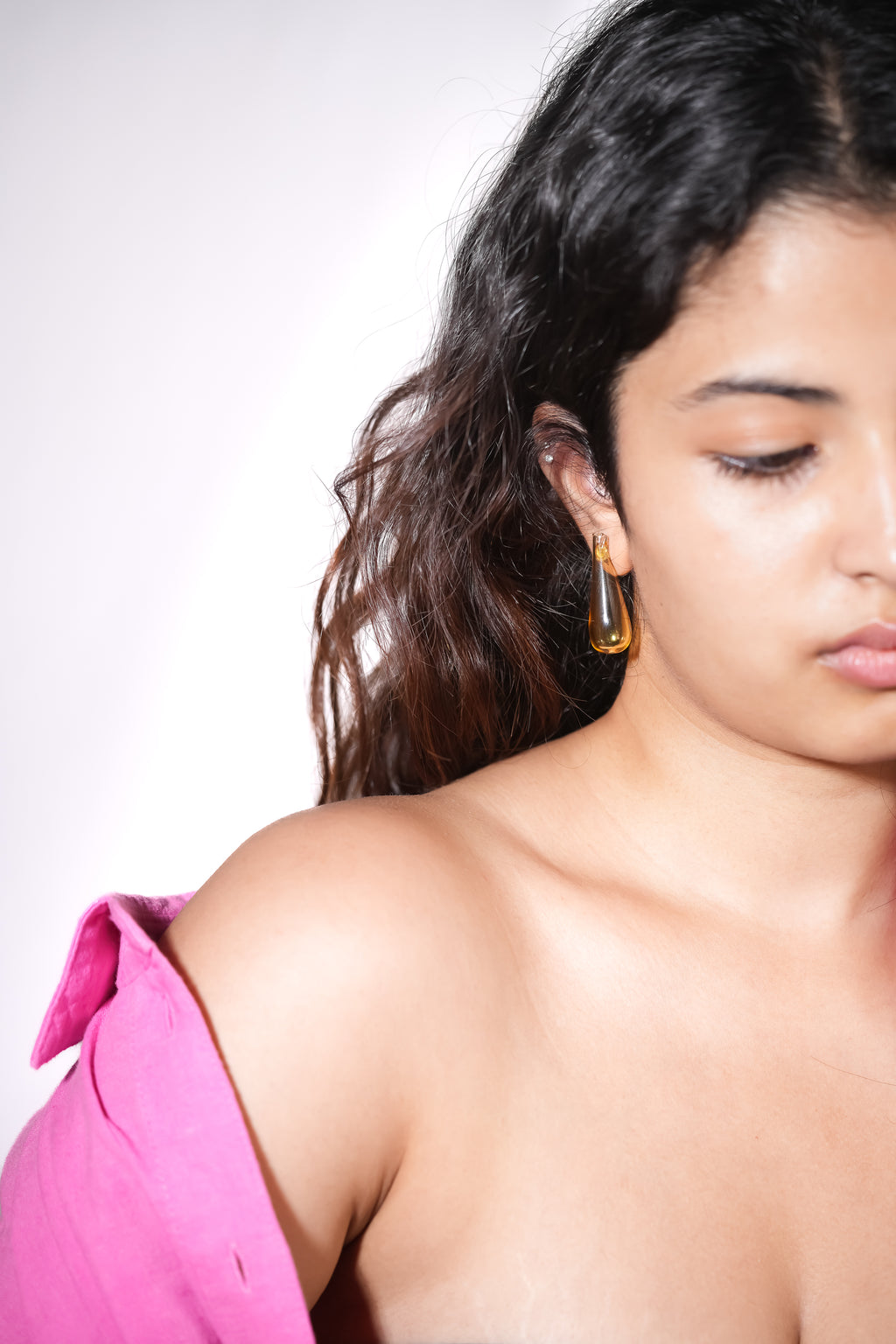 Model wearing handmade borosilicate glass teardrop earrings in yellow by AIROKAD STUDIO.