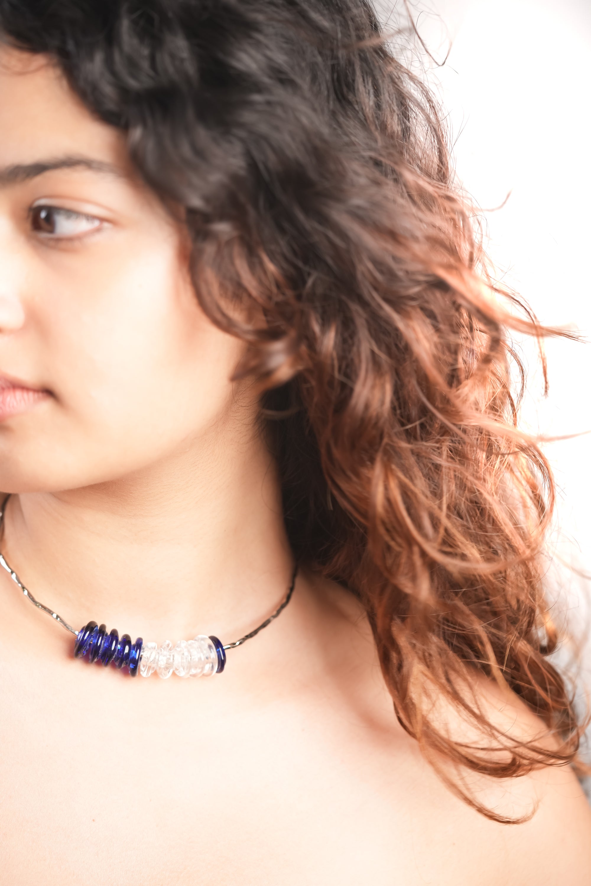 Model wearing handmade blue and clear glass bead choker by AIROKAD STUDIO