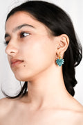 model wearing handcrafted borosilicate glass turquoise hoops in heart shape by AIROKAD STUDIO.